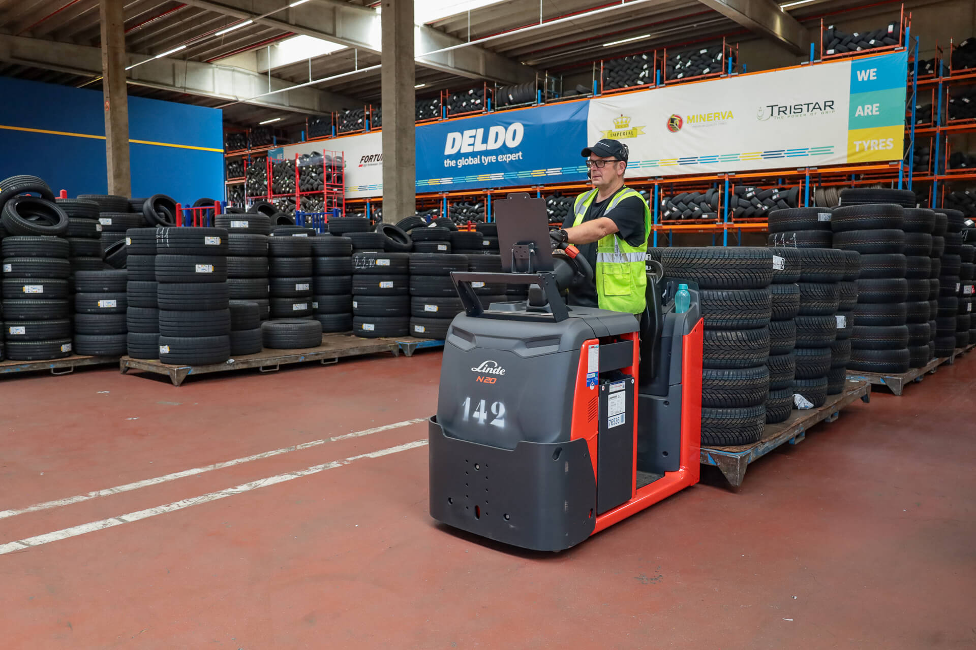 Linde orderpicktruck met stapel banden voor Deldo-banner