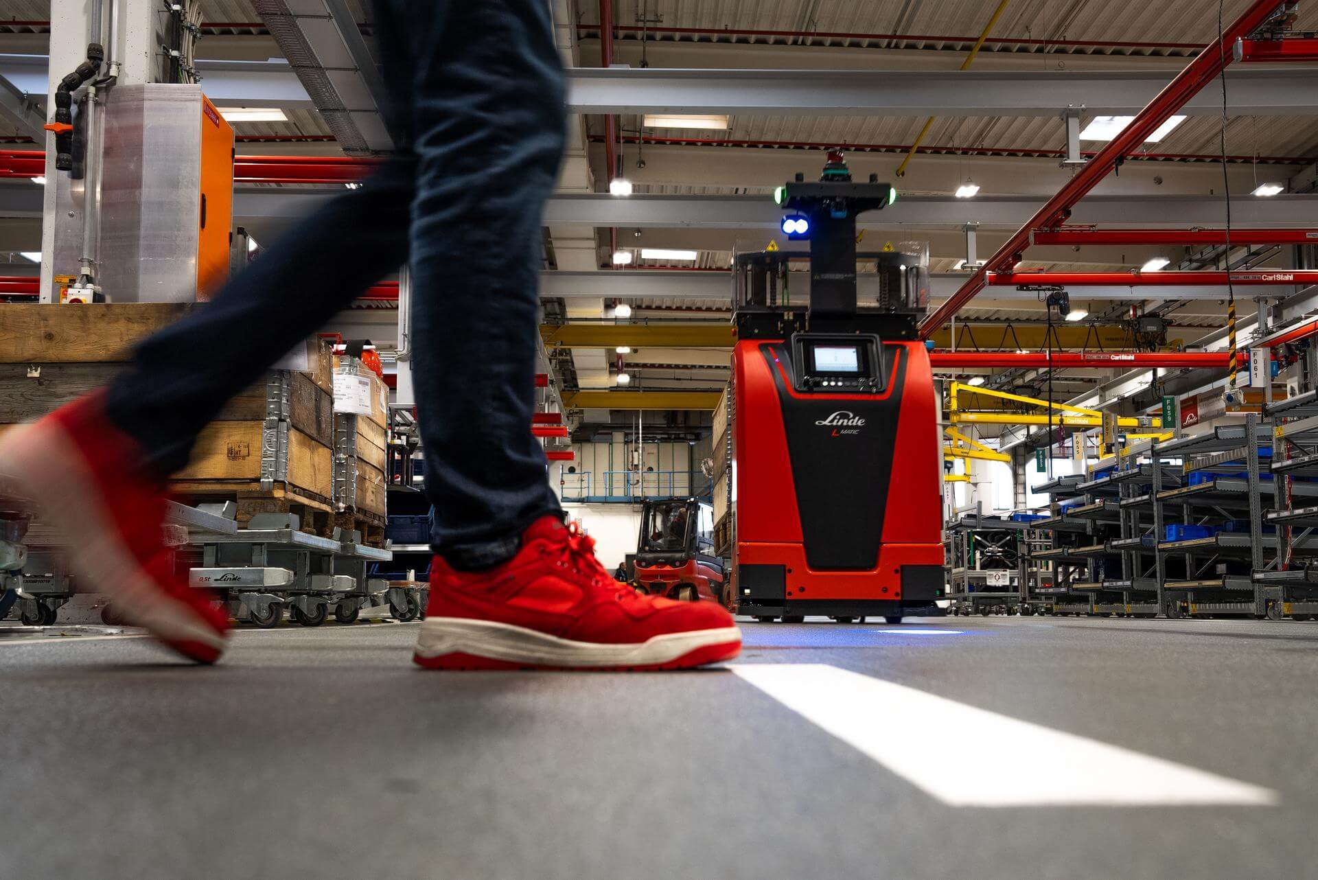 Linde L-MATIC core AGV autonome stapelaar komt veilig tot stilstand wanneer voetganger in het gangpad komt