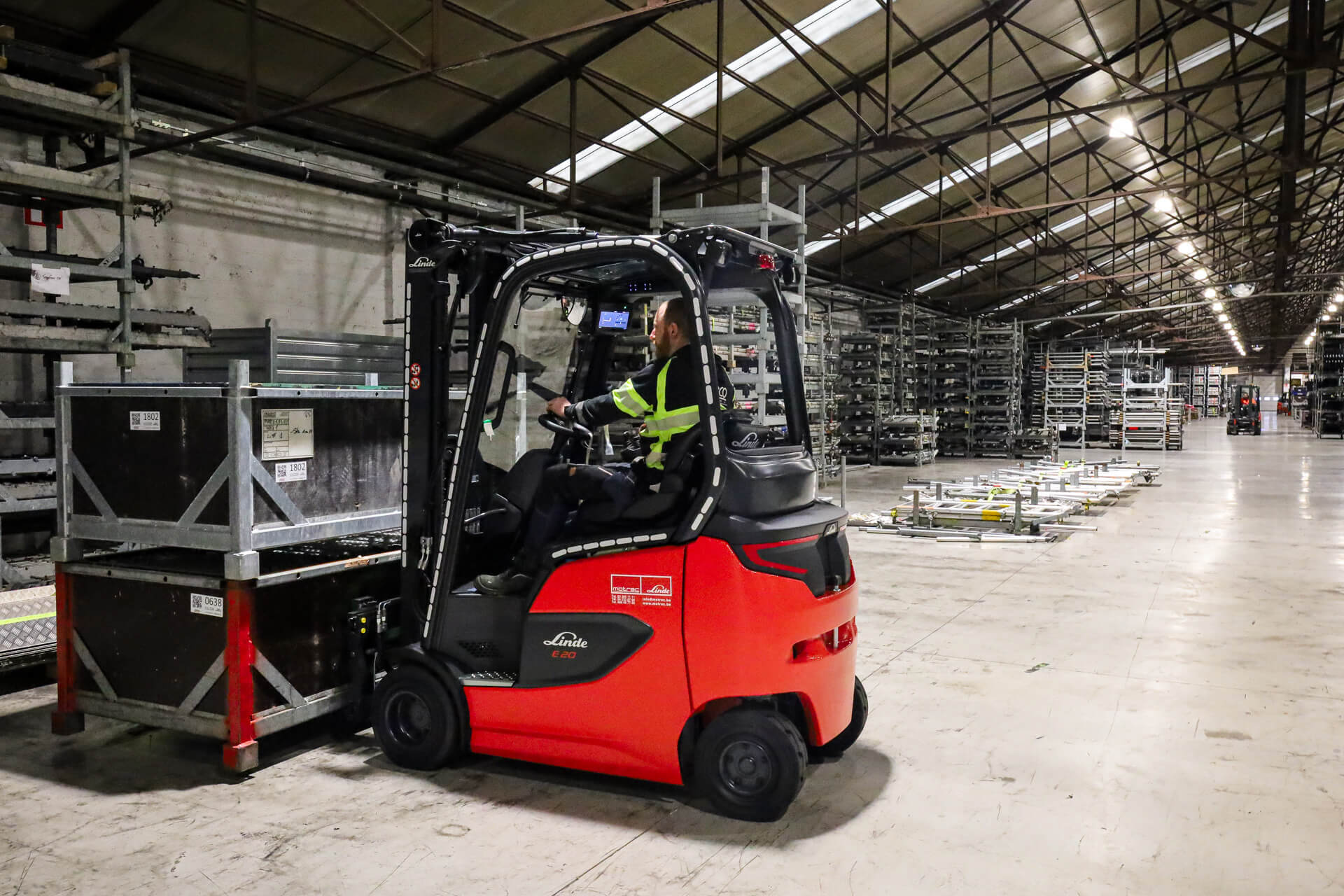 Linde E20 elektrische heftruck tilt bakken met materiaal op in magazijn Stageco