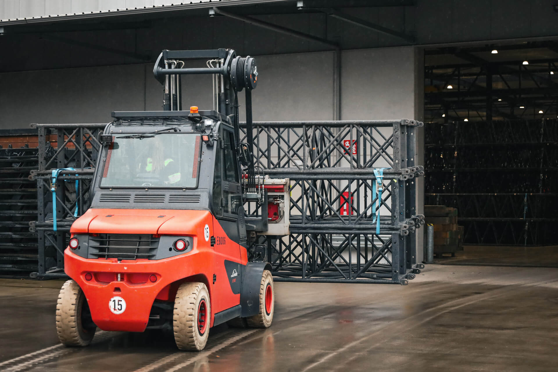 Linde E80 zware elektrische heftruck rijdt podiummateriaal het magazijn uit