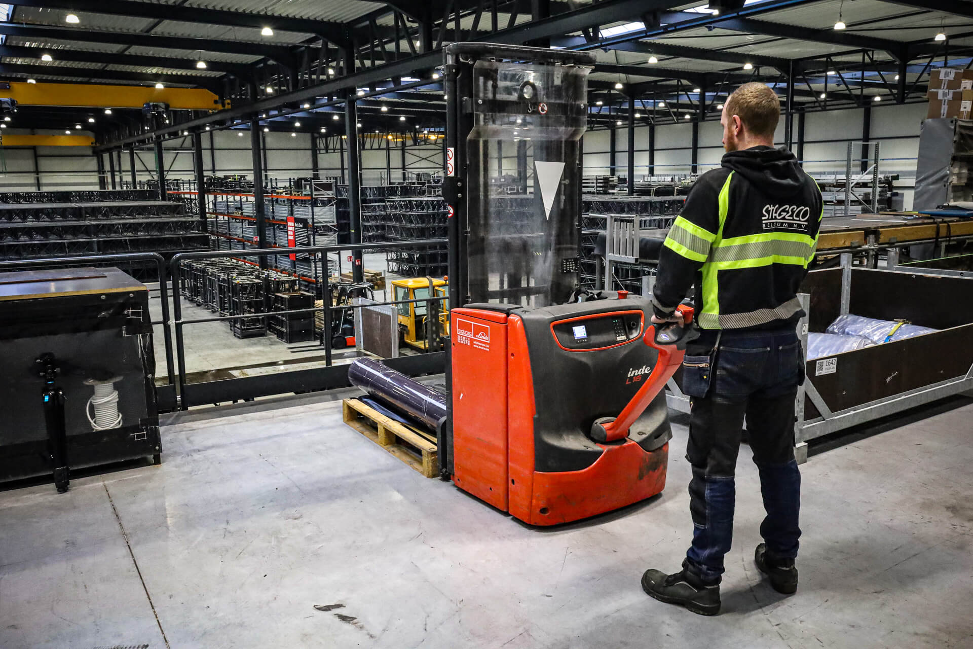 Linde E80 zware elektrische heftruck rijdt podiummateriaal het magazijn uit