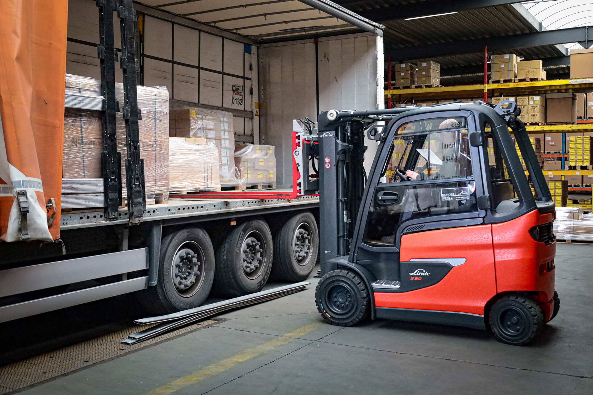 Linkerzijde van Linde elektrische heftruck die vrachtwagen inlaadt
