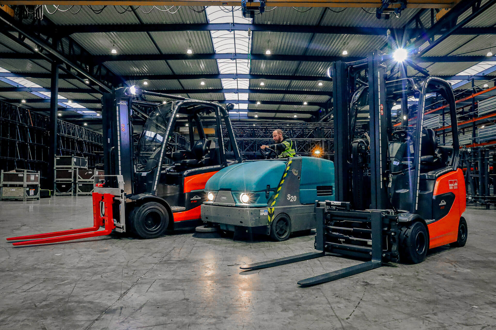 Tennant S20 veegmachine tussen twee Linde heftrucks